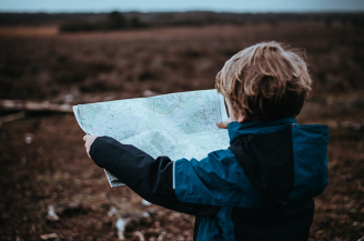 Viajar con niños mirando un mapa, en el campo